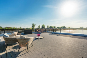 sunloungers and decking furniture sitting on a brown composite decking in the direct sunlight with clear blue skies